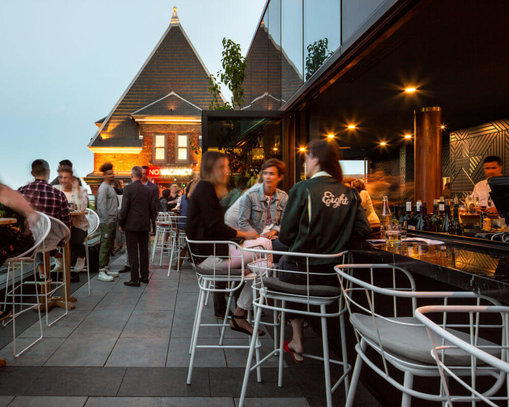 Dusk photo of people dining at the rooftop restaurant The Broadview Hotel