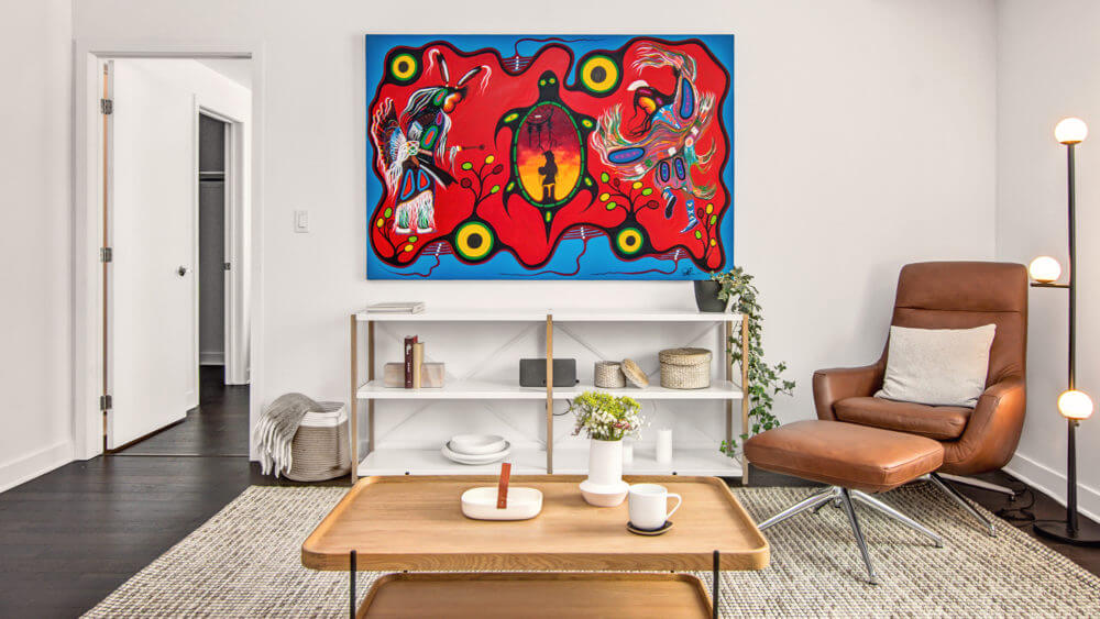 Photograph of living room with First Nation artwork hanging on the wall