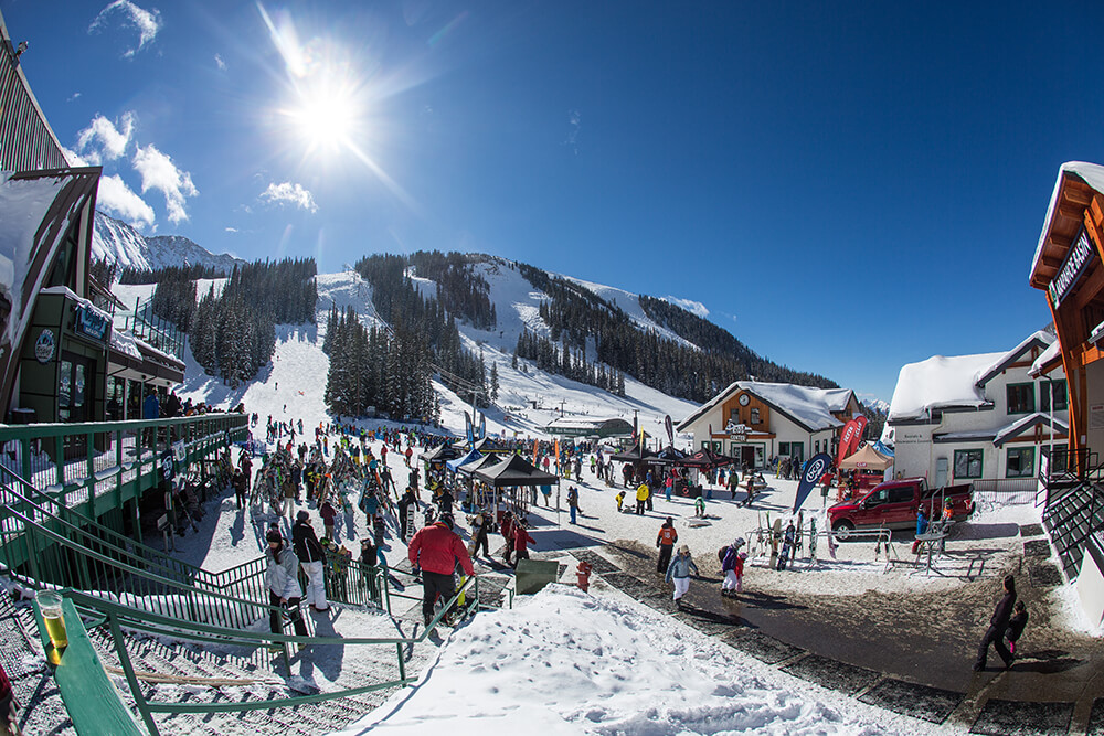 View of mountain goat plaza with a crowd of people walking around Arapahoe Basin