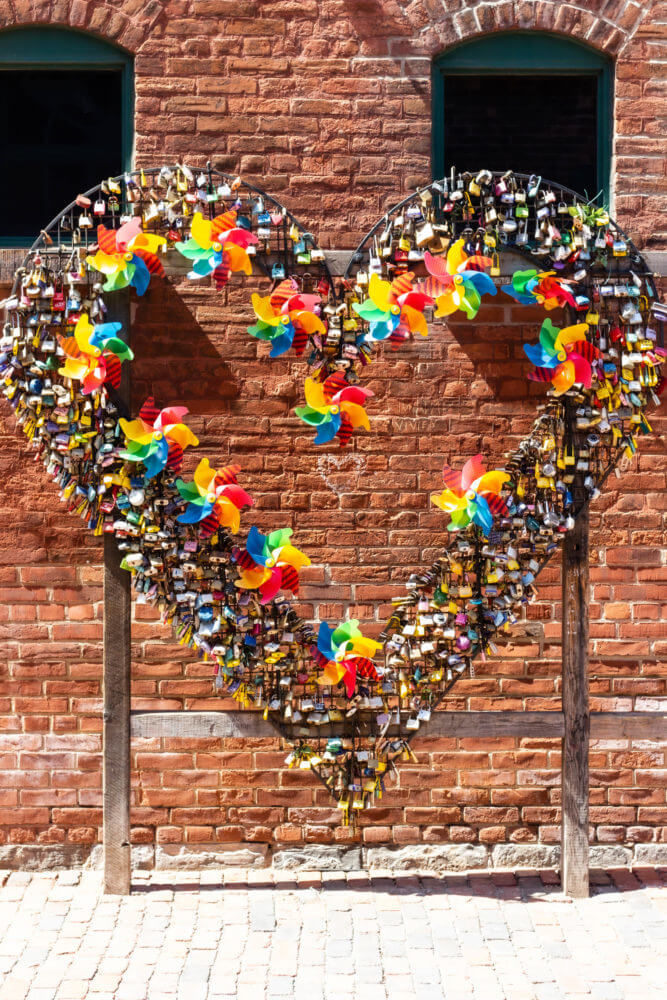 Love Locks installation in Distillery District, lock locked on a metal heart shape in front of a brick wall