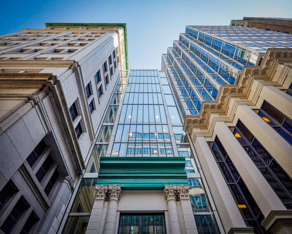 view upwards from the street of 36 Toronto Facade, integrating modern glass with the original white columns and exterior.