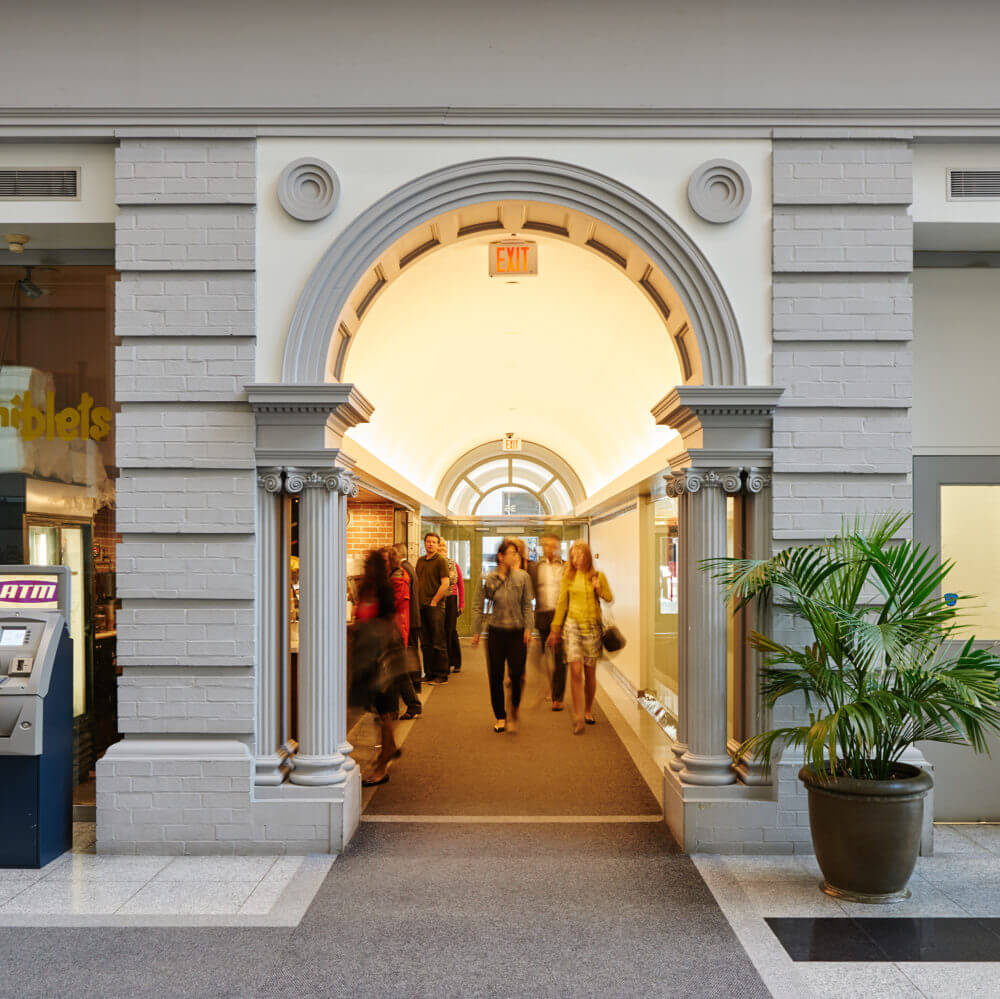 Interior of 36 Toronto Street showing a archway with columns and people walking through.