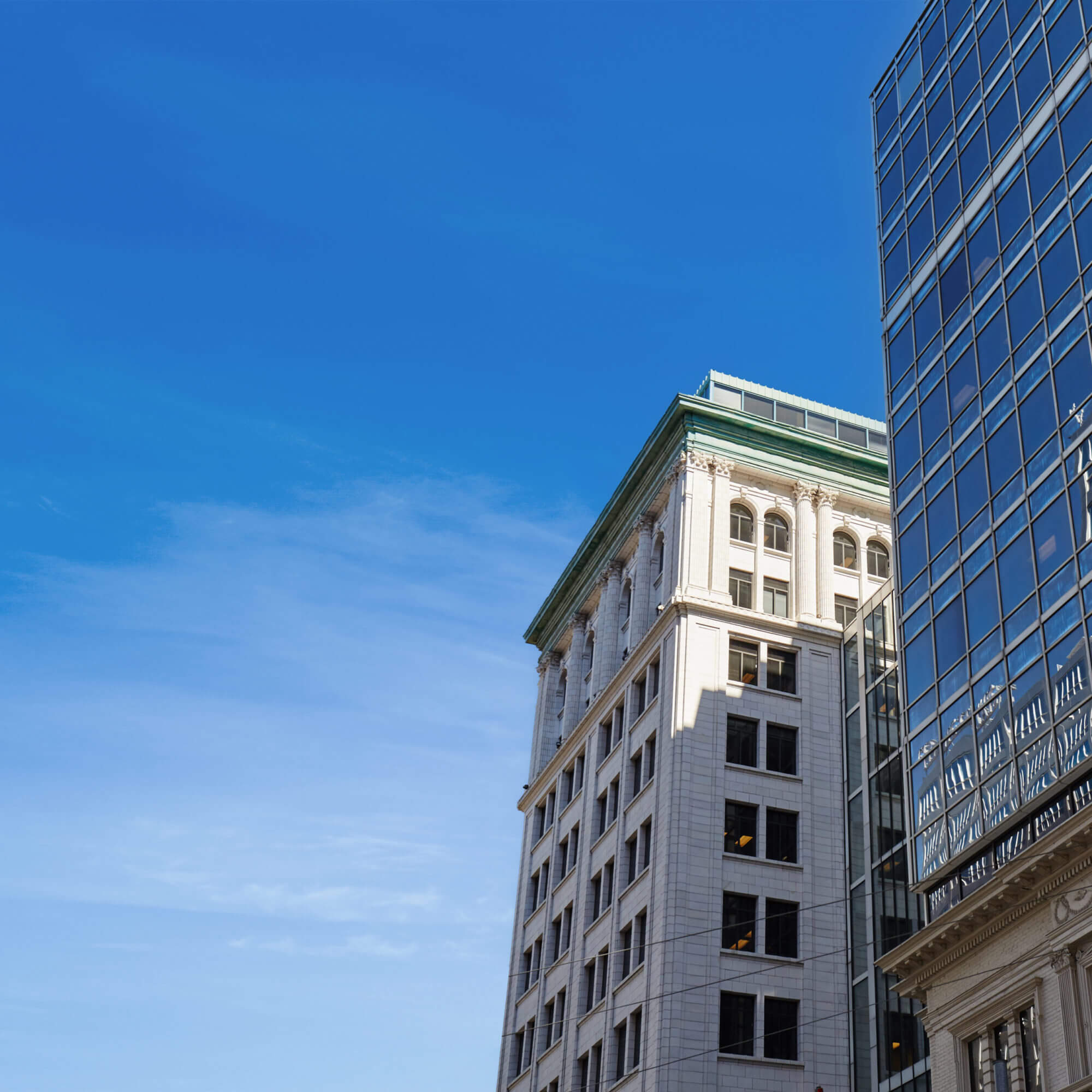 Street level upwards view of 36 Toronto Street, a historical white building tower with a green roof.