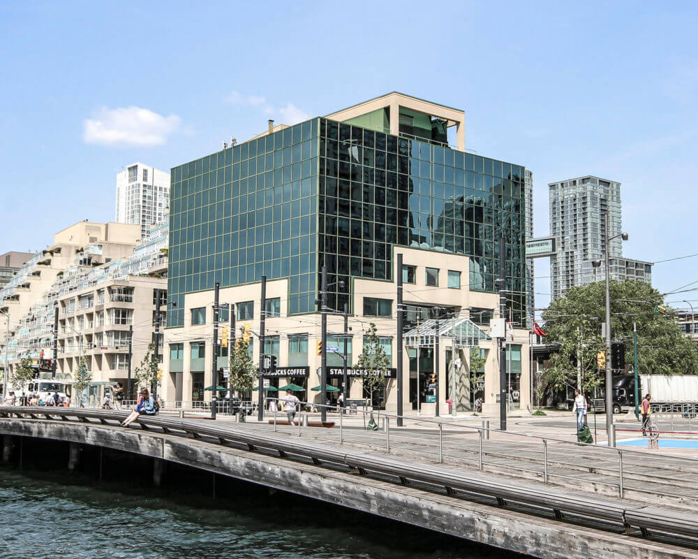 image of the waterfront Spadina Quay Office Complex - 10 Lower Spadina Ave. with people walking along the lake shore