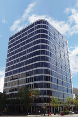 Perspective view of Saskatoon Square, a tall glass building with rounded corners