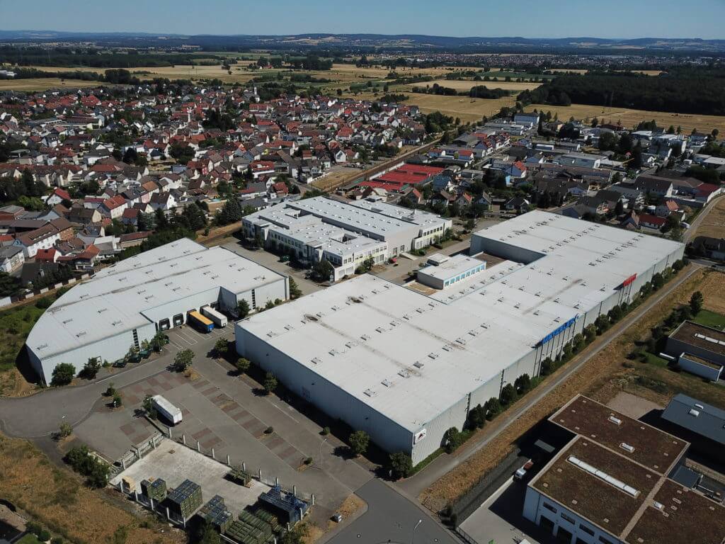 Aerial image of Dream Industrial Warehouse Building in Germany surrounded by a village of other buildings.