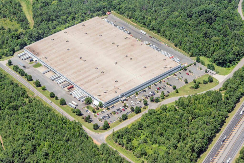 Aerial image of Dream Industrial Warehouse Building in Cornwall surrounded by trees.