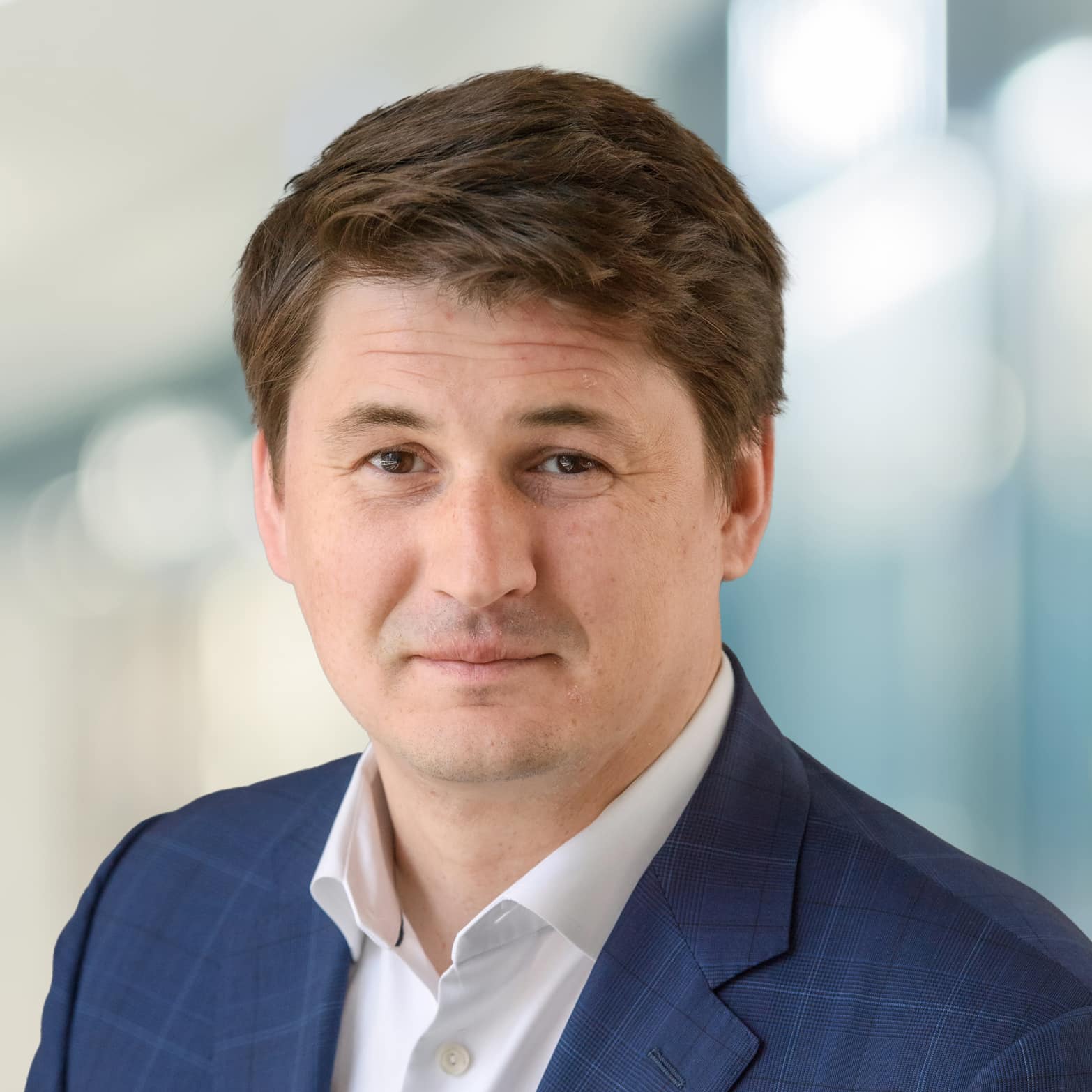 A smiling headshot of Alexander Sannikov, President and Chief Operating Officer of Dream Industrial, against a blurry background