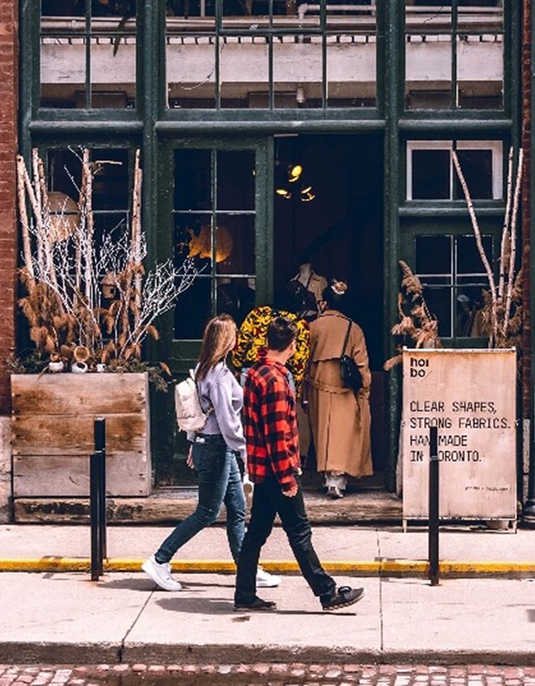 a couple stroll through the Distillery District as they window shop